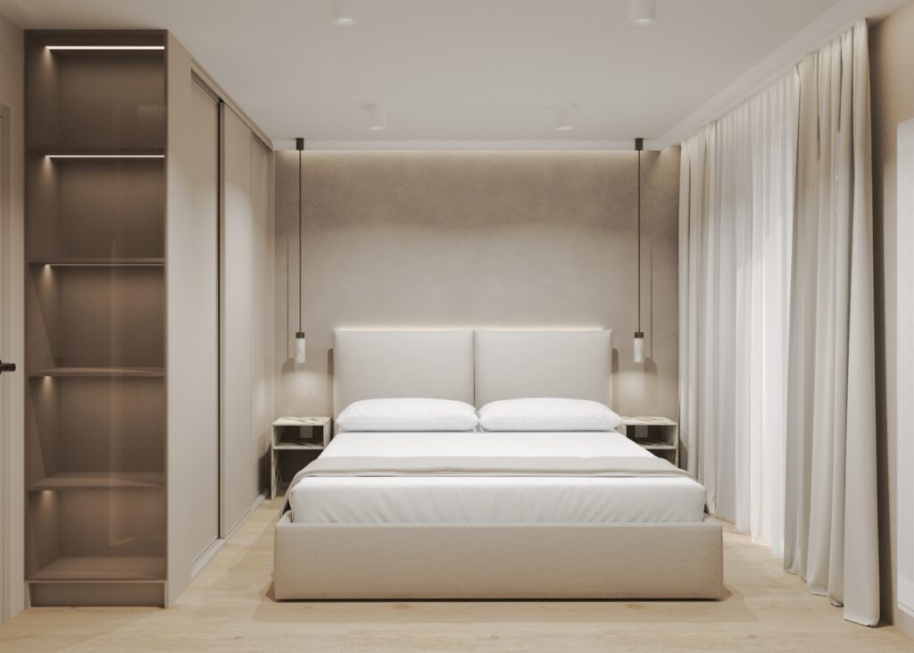 Nowoczesna sypialnia w jasnych, beżowych tonach z dużym łóżkiem o tapicerowanym zagłówku, otoczonym wbudowanymi szafami i długimi, białymi zasłonami. Po lewej stronie znajdują się oświetlone półki, a nad łóżkiem wiszą dwie lampy wiszące.