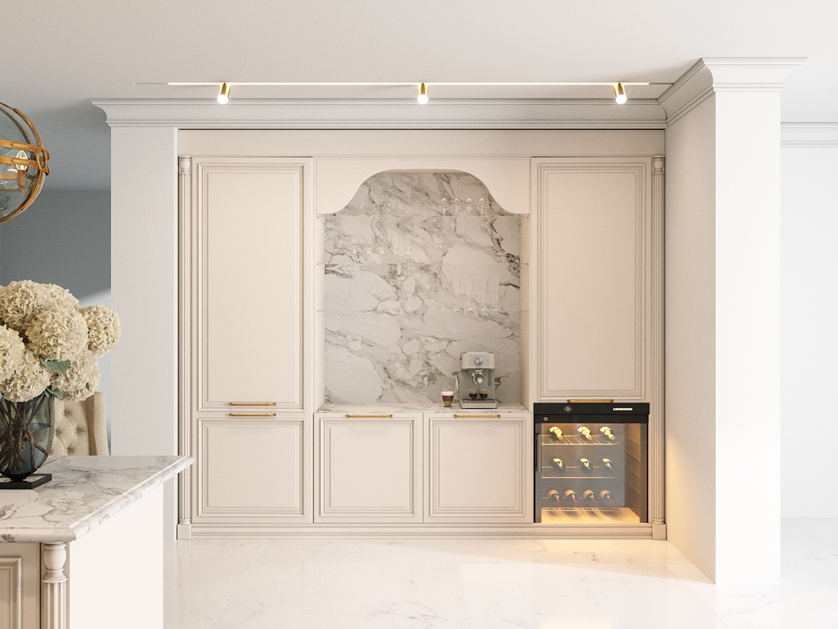 Elegancka kuchnia w jasnych tonach z białymi szafkami z złotymi uchwytami i wbudowaną lodówką na wino. Na marmurowym blacie stoi wazon z białymi kwiatami, a ścianę zdobi dekoracyjna niша z marmurowym wykończeniem.