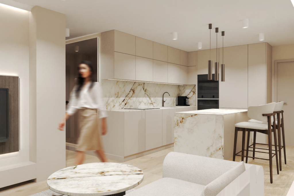 Nowoczesna kuchnia w jasnych kolorach z beżowymi szafkami, marmurowymi blatami i wyspą kuchenną z hokerami. Kobieta w białej bluzce i beżowej spódnicy przechodzi przez przestrzeń, tworząc efekt ruchu na zdjęciu.